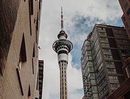Low angle shot of the Sky Tower amongst buildings image